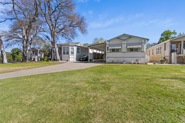 a front view of a house with a yard and trees