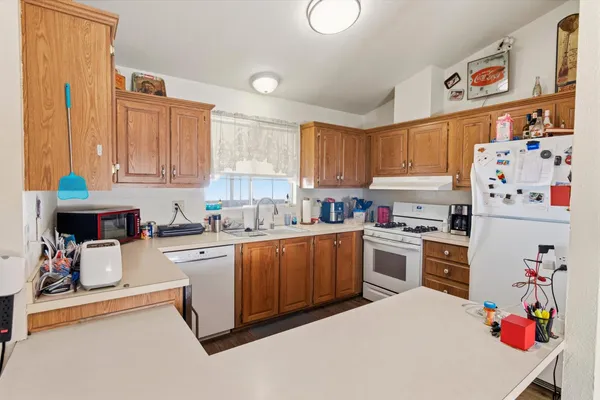 a kitchen with kitchen island a white wooden cabinets and white appliances