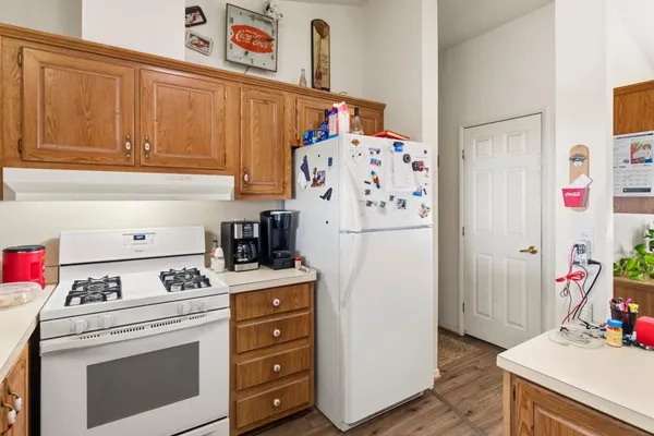 a kitchen with a refrigerator and white stove top oven