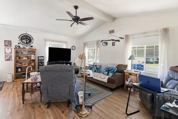 a living room with furniture a flat screen tv and wooden floor