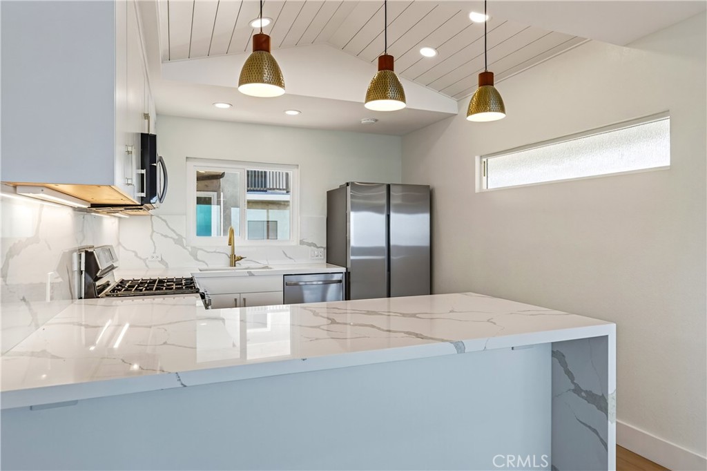 34381 Dana Strand Road, Unit 2 Dana Point, CA 92629 - Photo 6 of 42 a large kitchen with stainless steel appliances kitchen island a chandelier