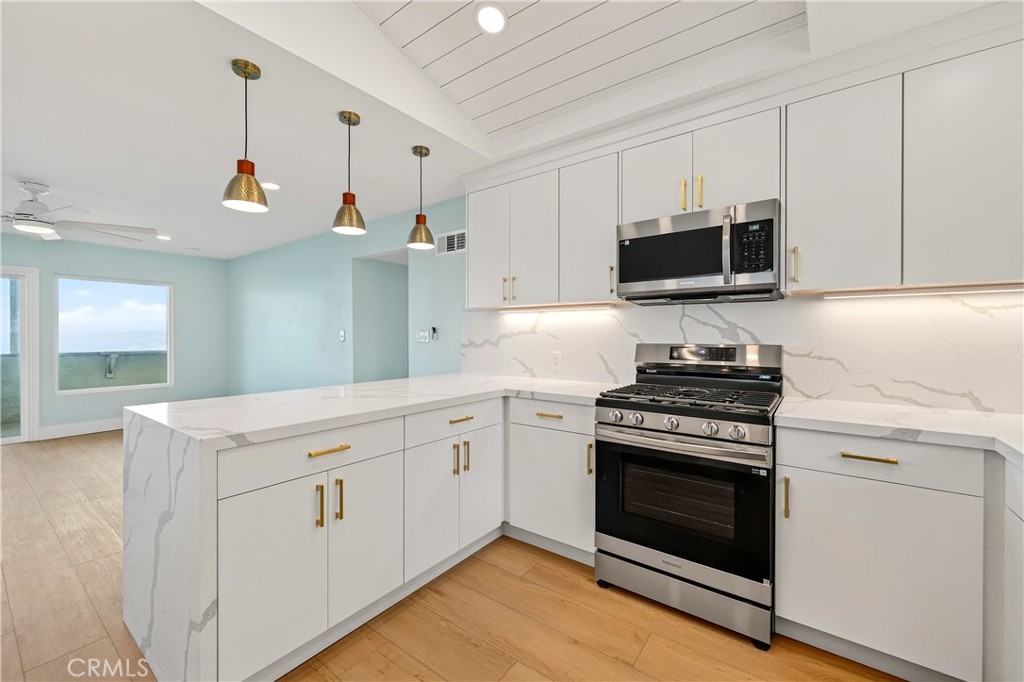 34381 Dana Strand Road, Unit 2 Dana Point, CA 92629 - Photo 10 of 42 a kitchen with cabinets stainless steel appliances and wooden floor