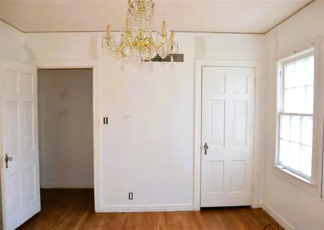 a view of a small space with wooden floor and chandelier