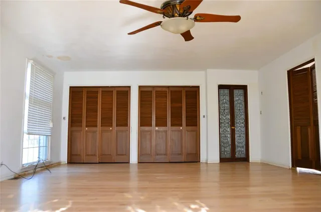 an empty room with wooden floor and windows
