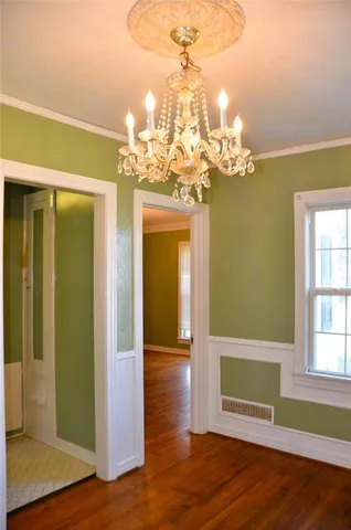 a view of a room with wooden floor and chandelier