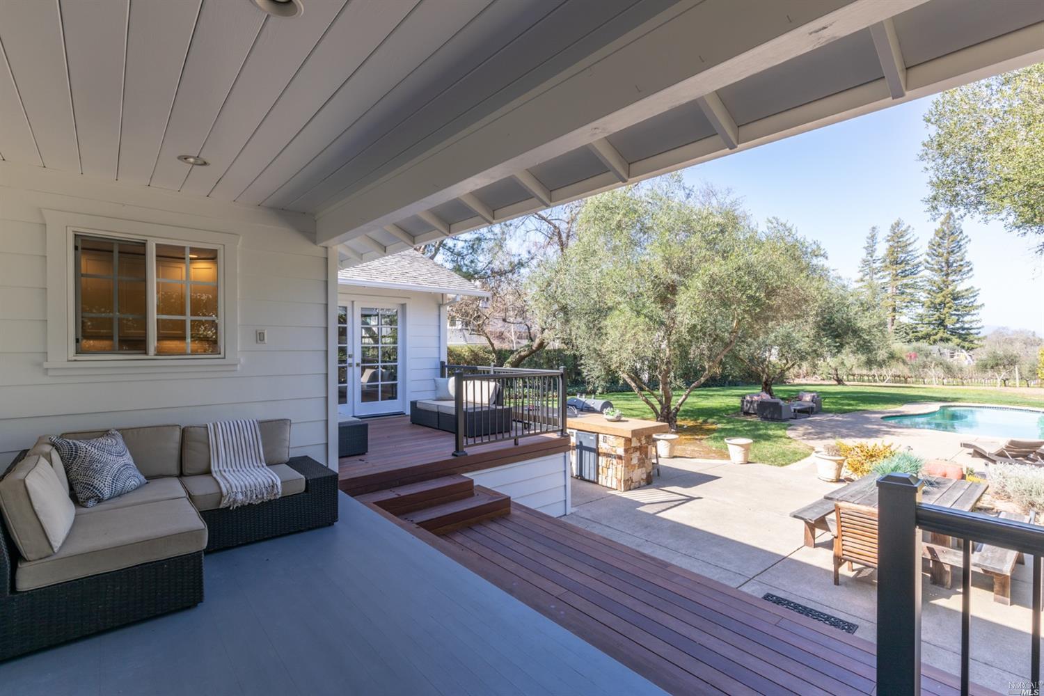a living room with patio furniture and a lake view