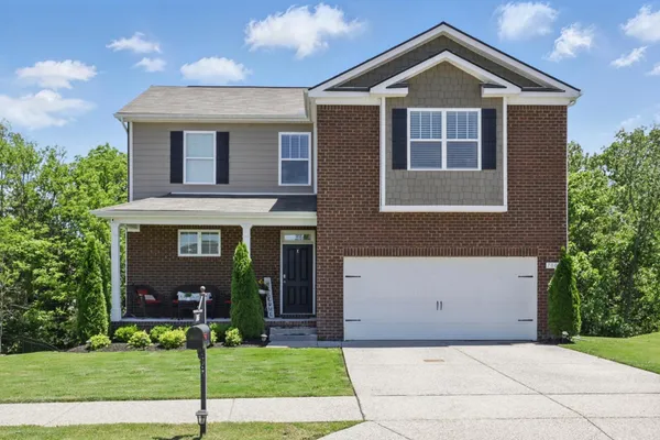 a front view of a house with a yard and garage
