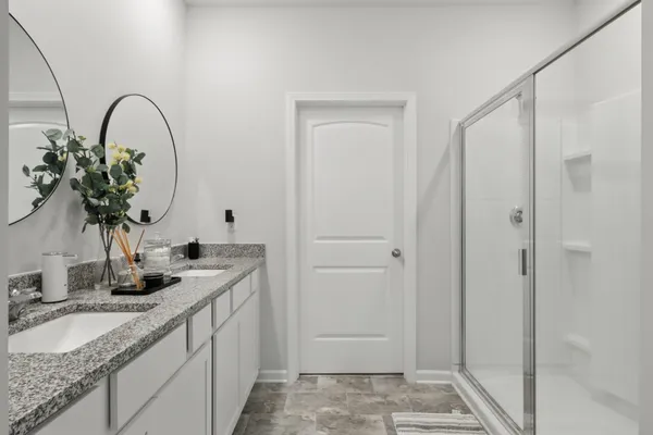 a bathroom with a granite countertop sink a mirror and a shower