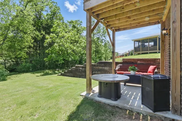 a view of a backyard with table and chairs potted plants and floor to ceiling window