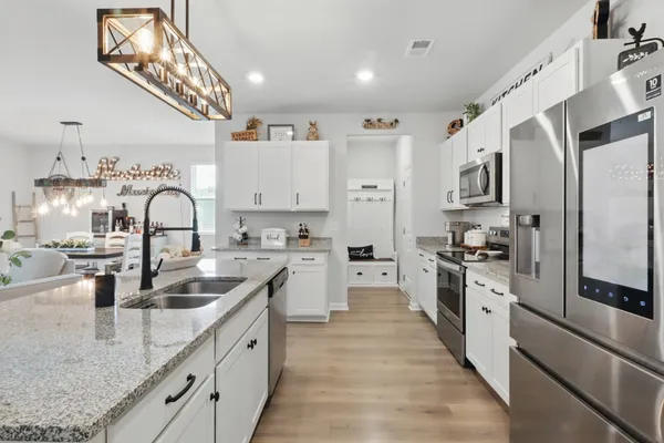a large kitchen with stainless steel appliances granite countertop a sink dishwasher a refrigerator oven with a stove and cabinets