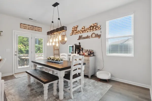 a dining room with wooden floor and a chandelier