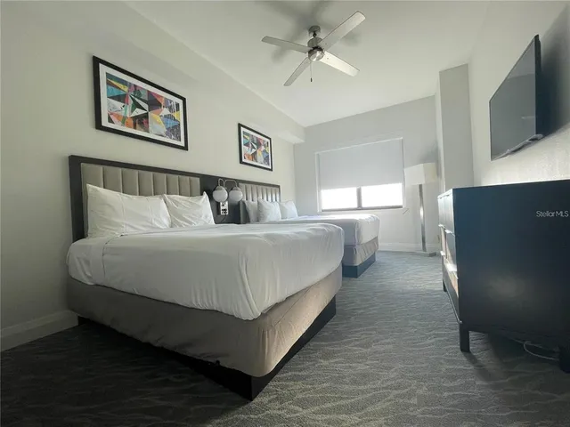 a spacious bedroom with a bed and a flat screen tv