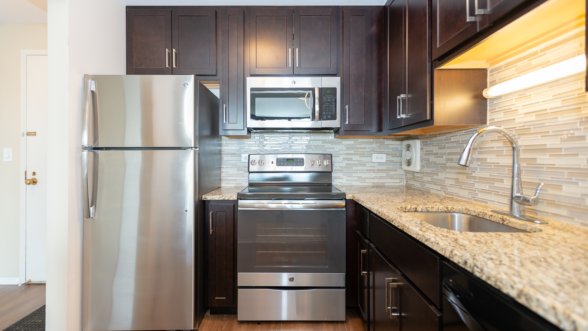 111 West Maple Street, Unit 1110 Chicago, IL 60610 - Photo 11 of 23 a kitchen with granite countertop stainless steel appliances and refrigerator