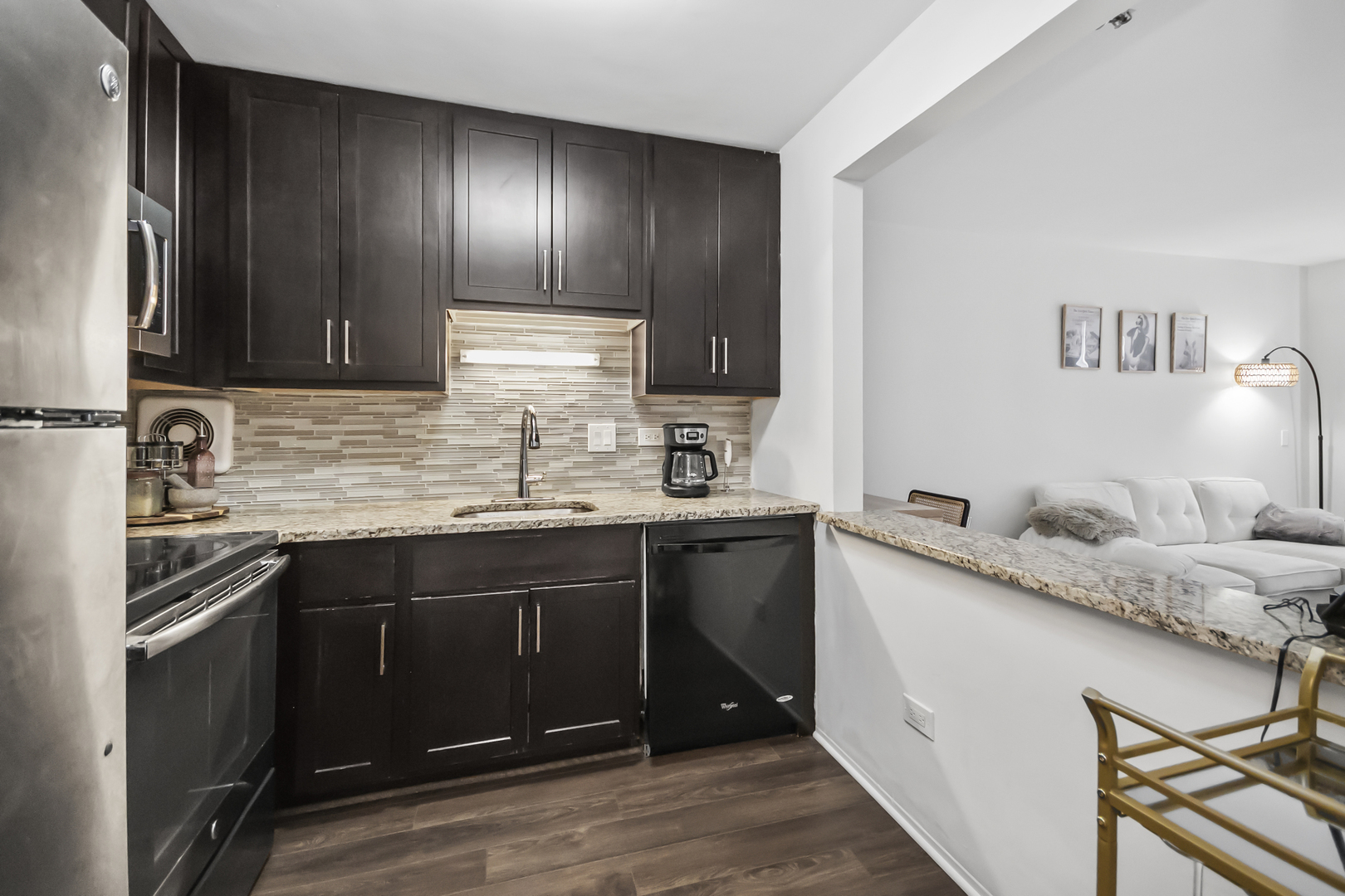 111 West Maple Street, Unit 1110 Chicago, IL 60610 - Photo 12 of 23 a kitchen with stainless steel appliances granite countertop a sink stove and cabinets