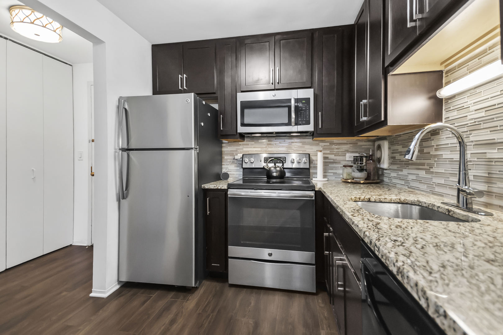 111 West Maple Street, Unit 1110 Chicago, IL 60610 - Photo 13 of 23 a kitchen with granite countertop a refrigerator stove and sink