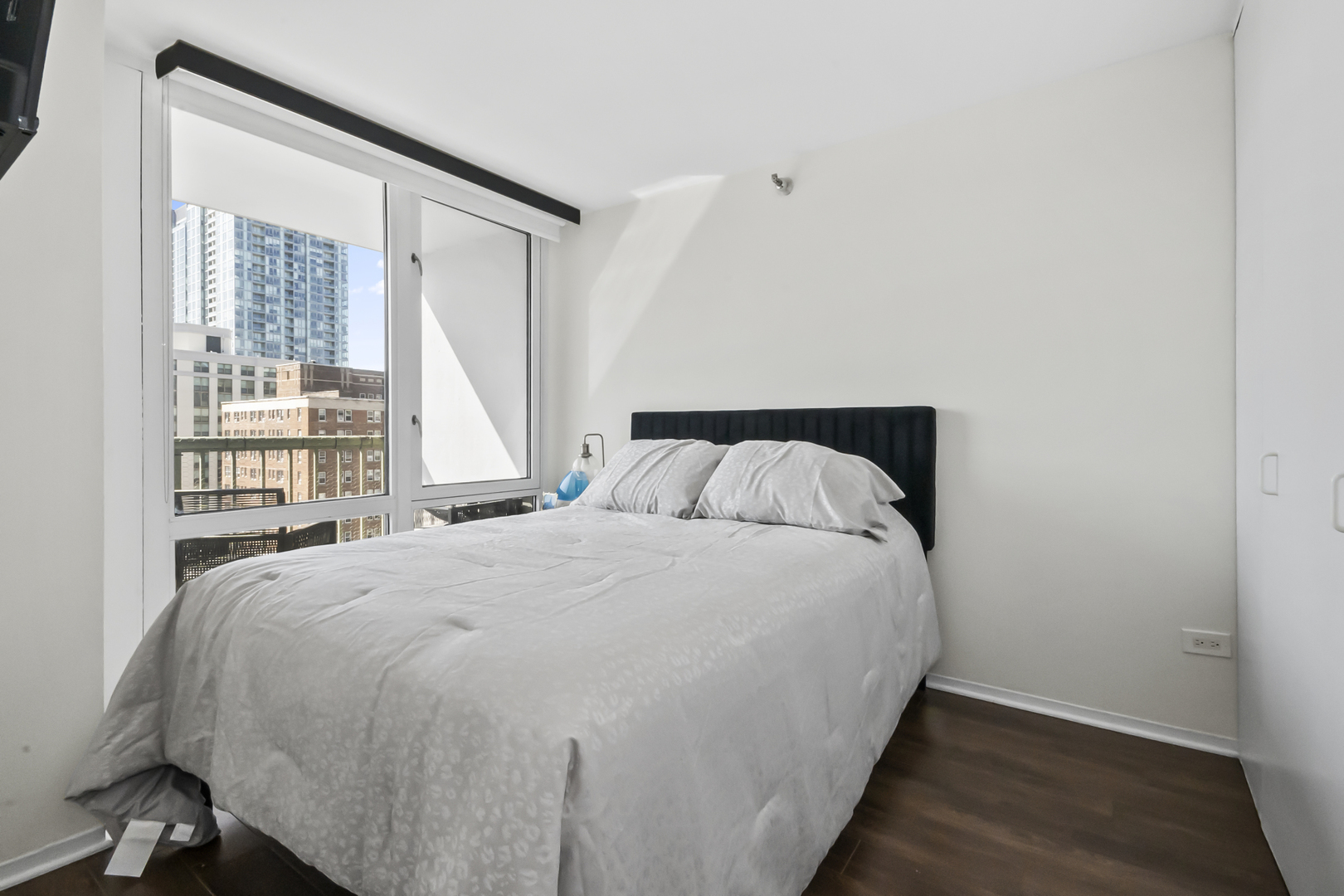 111 West Maple Street, Unit 1110 Chicago, IL 60610 - Photo 14 of 23 a large bed sitting in a bedroom next to a window
