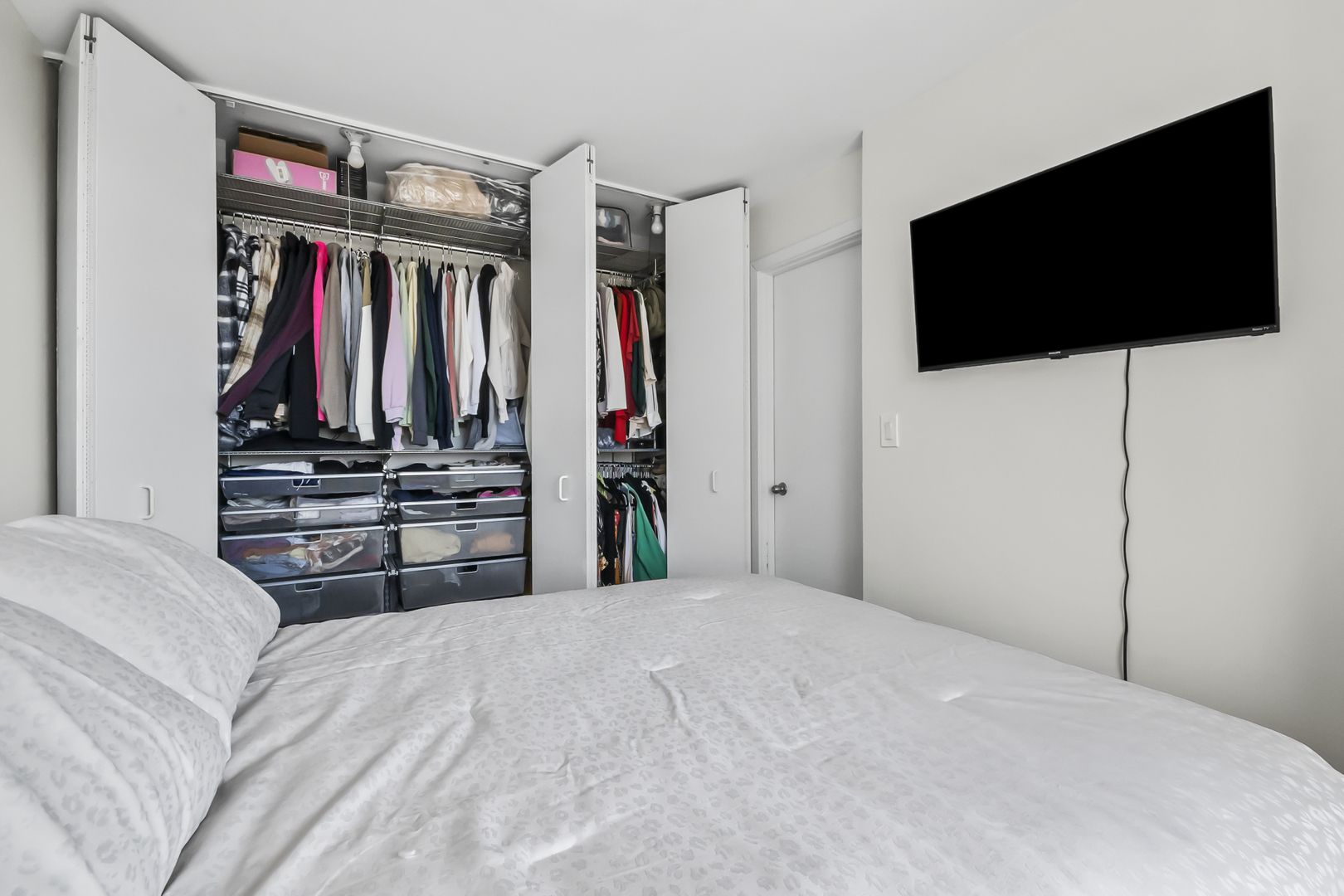 111 West Maple Street, Unit 1110 Chicago, IL 60610 - Photo 15 of 23 a bedroom with a bed and a flat screen tv
