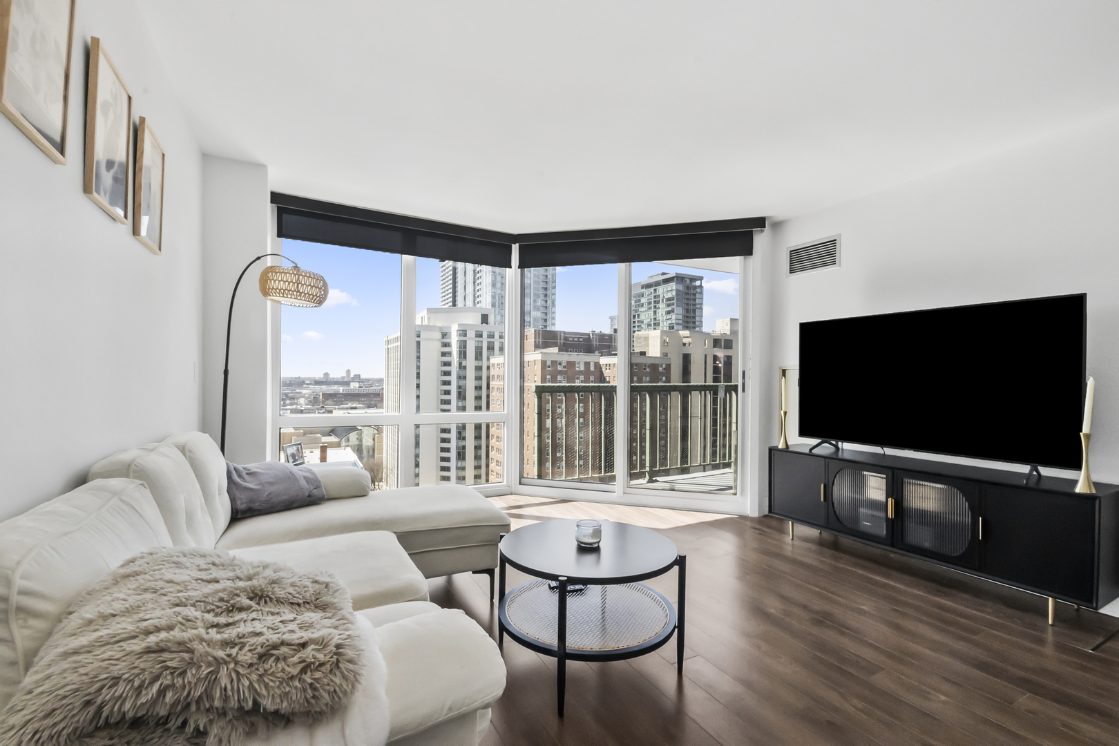 111 West Maple Street, Unit 1110 Chicago, IL 60610 - Photo 3 of 23 a living room with furniture a flat screen tv and floor to ceiling window