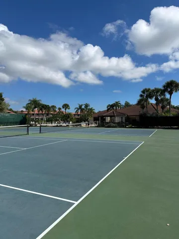 a view of a big house next to a yard with big trees