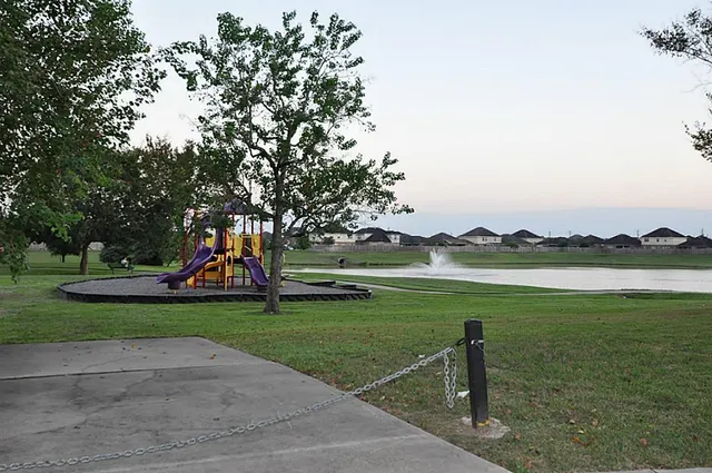 a view of a lake with a yard and a large tree