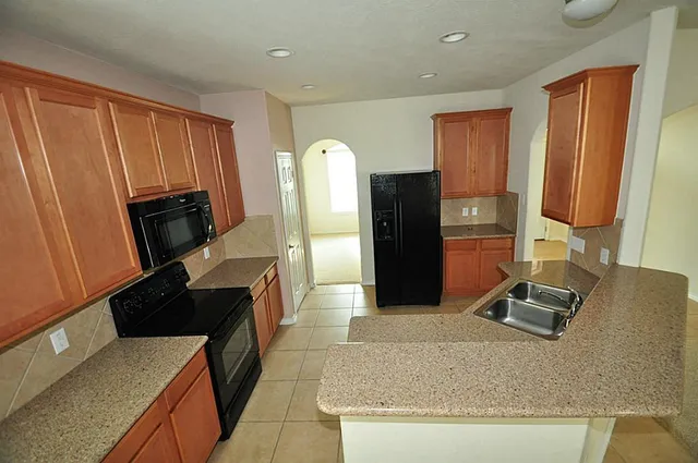 a kitchen with stainless steel appliances granite countertop a refrigerator and a stove