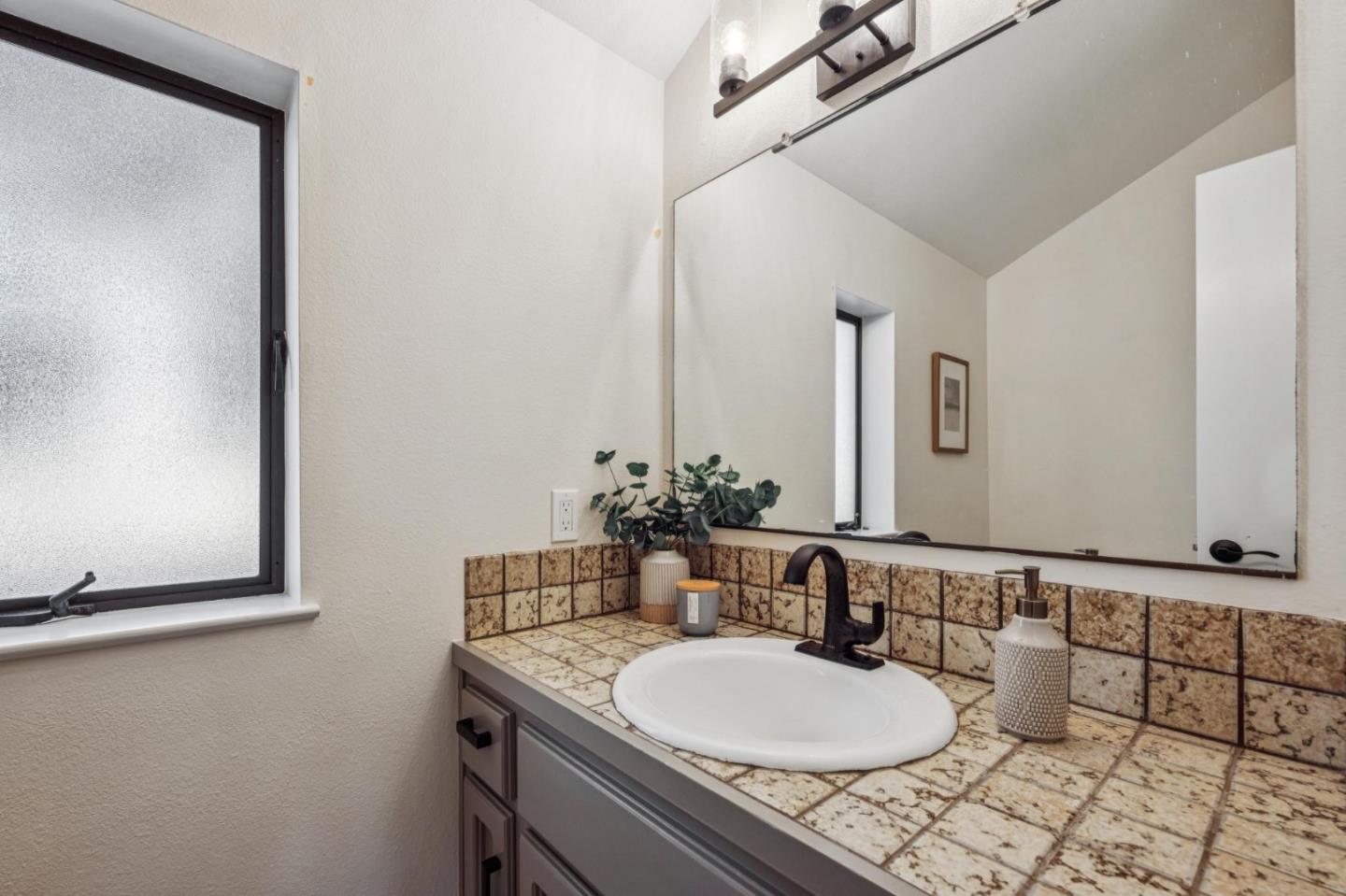 1100 Castro Road Monterey, CA 93940 - Photo 59 of 70 a bathroom with a granite countertop sink and a mirror
