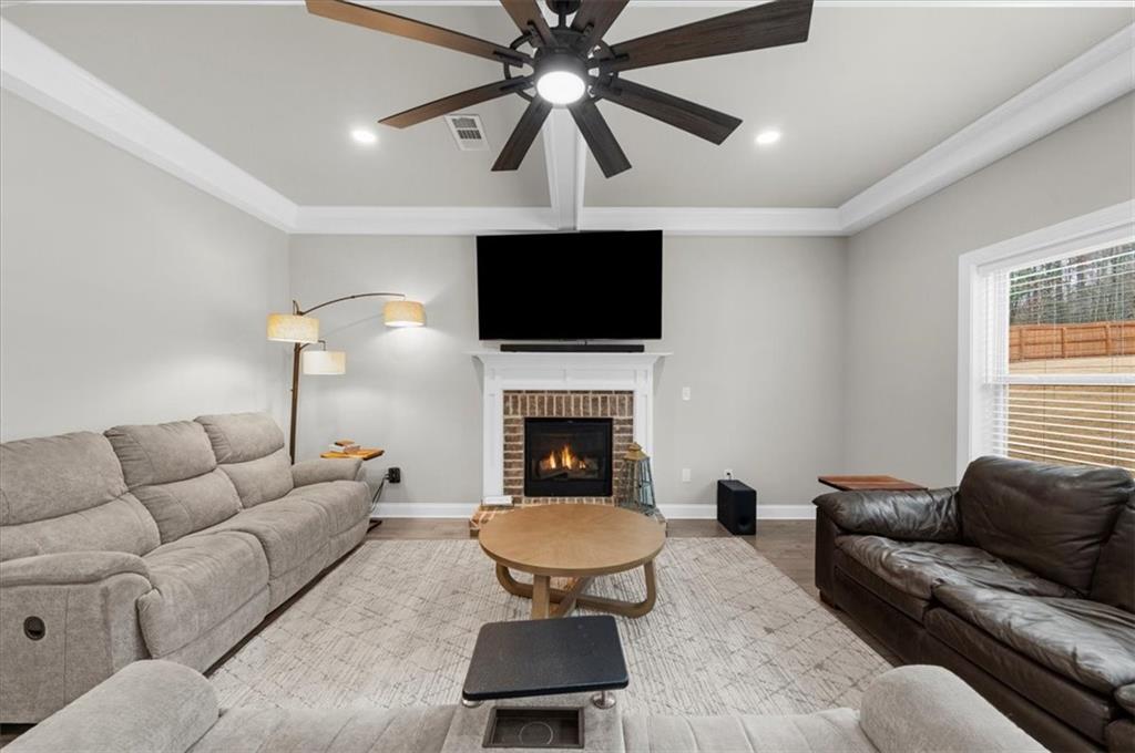 182 Bella Drive Monroe, GA 30655 - Photo 16 of 63 a living room with furniture a flat screen tv and a fireplace
