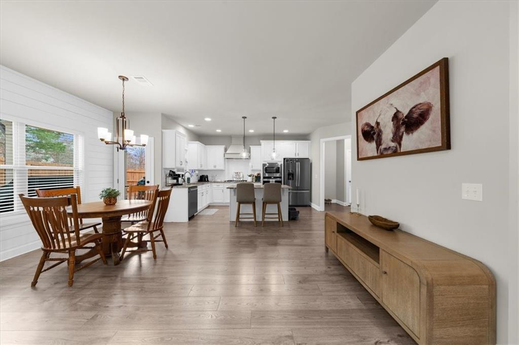 182 Bella Drive Monroe, GA 30655 - Photo 19 of 63 a view of a dining room with furniture and wooden floor
