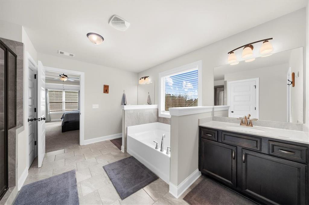 182 Bella Drive Monroe, GA 30655 - Photo 38 of 63 a en suite bathroom with a double vanity sink a mirror and a shower