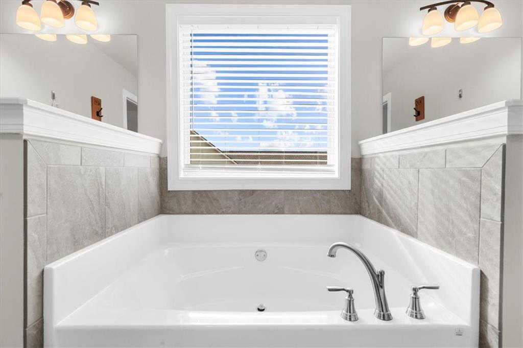 182 Bella Drive Monroe, GA 30655 - Photo 40 of 63 a bathroom with bathtub and window