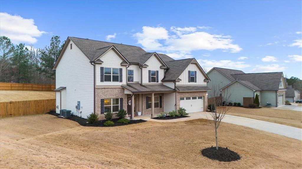 182 Bella Drive Monroe, GA 30655 - Photo 52 of 63 a front view of a house with a yard and garage