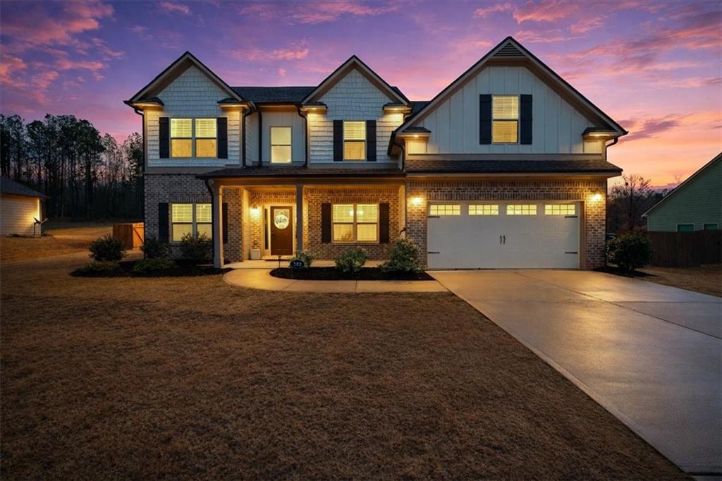 182 Bella Drive Monroe, GA 30655 - Photo 60 of 63 a front view of a house with a yard and garage