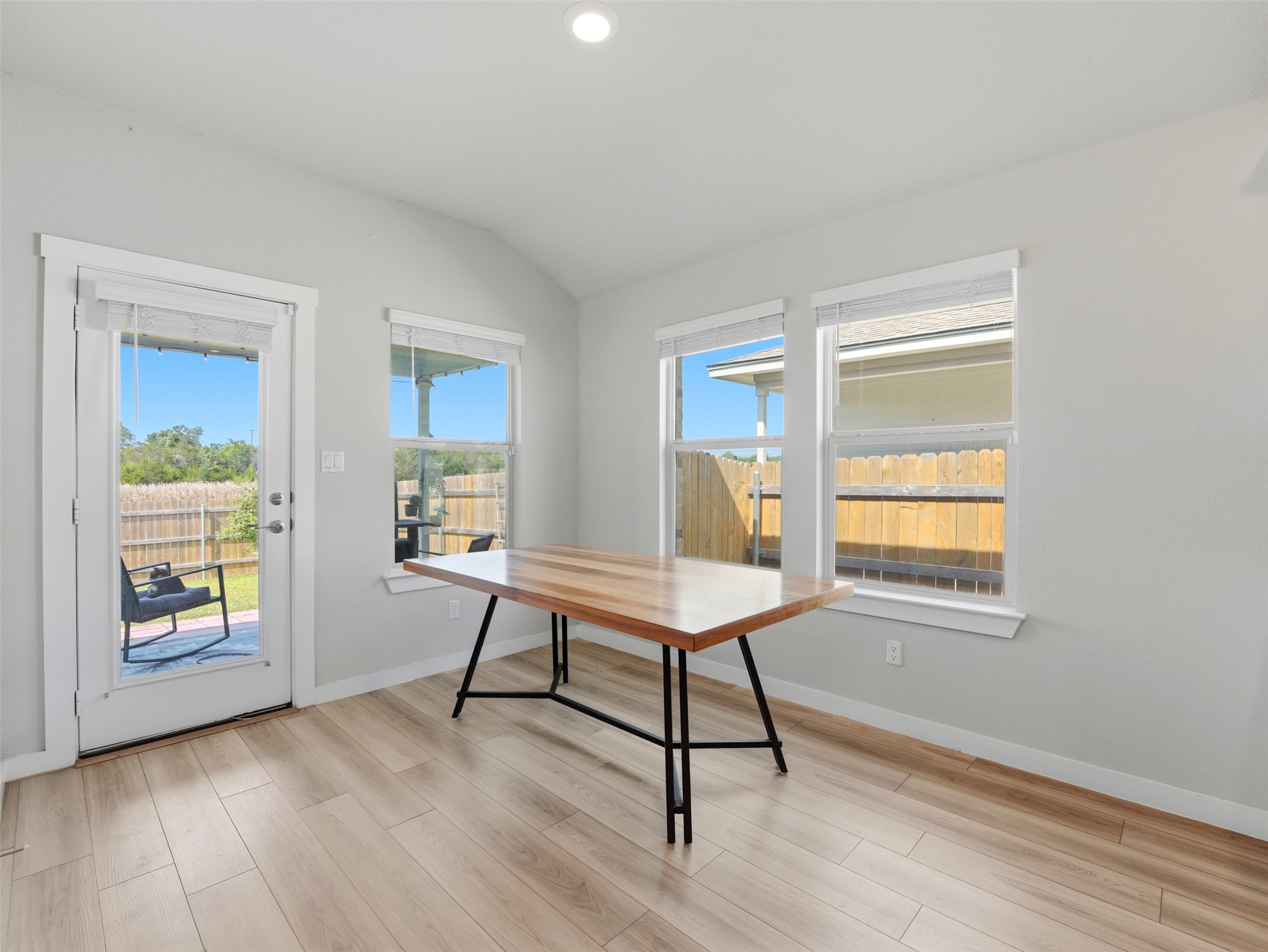 1024 Tipton Street Georgetown, TX 78633 - Photo 8 of 32 A well-lit interior space features sleek wood flooring and a rear entry to a fenced outdoor area.