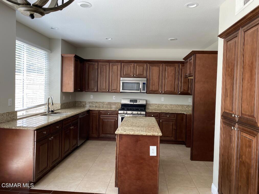 2753 Titania Place Simi Valley, CA 93063 - Photo 2 of 14 a kitchen with wooden cabinets a sink a stove a refrigerator and a window