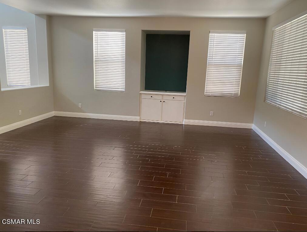2753 Titania Place Simi Valley, CA 93063 - Photo 4 of 14 an empty room with wooden floor and windows