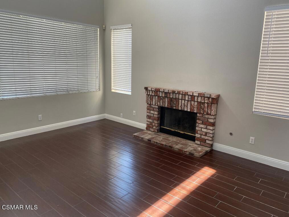 2753 Titania Place Simi Valley, CA 93063 - Photo 5 of 14 an empty room with wooden floor fireplace and windows