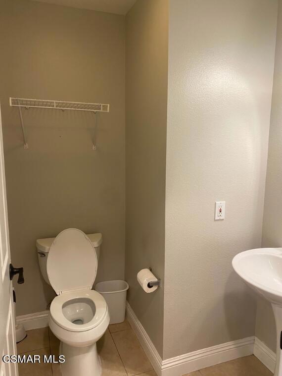 2753 Titania Place Simi Valley, CA 93063 - Photo 6 of 14 a white toilet sitting in a bathroom next to a wooden wall