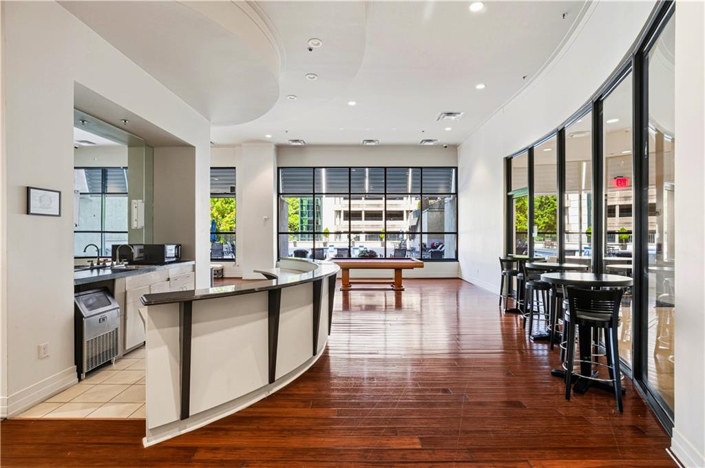 3040 Peachtree Road Northwest, Unit 1503 Atlanta, GA 30305 - Photo 30 of 38 a kitchen with stainless steel appliances granite countertop a stove top oven a dining table and chairs with wooden floor