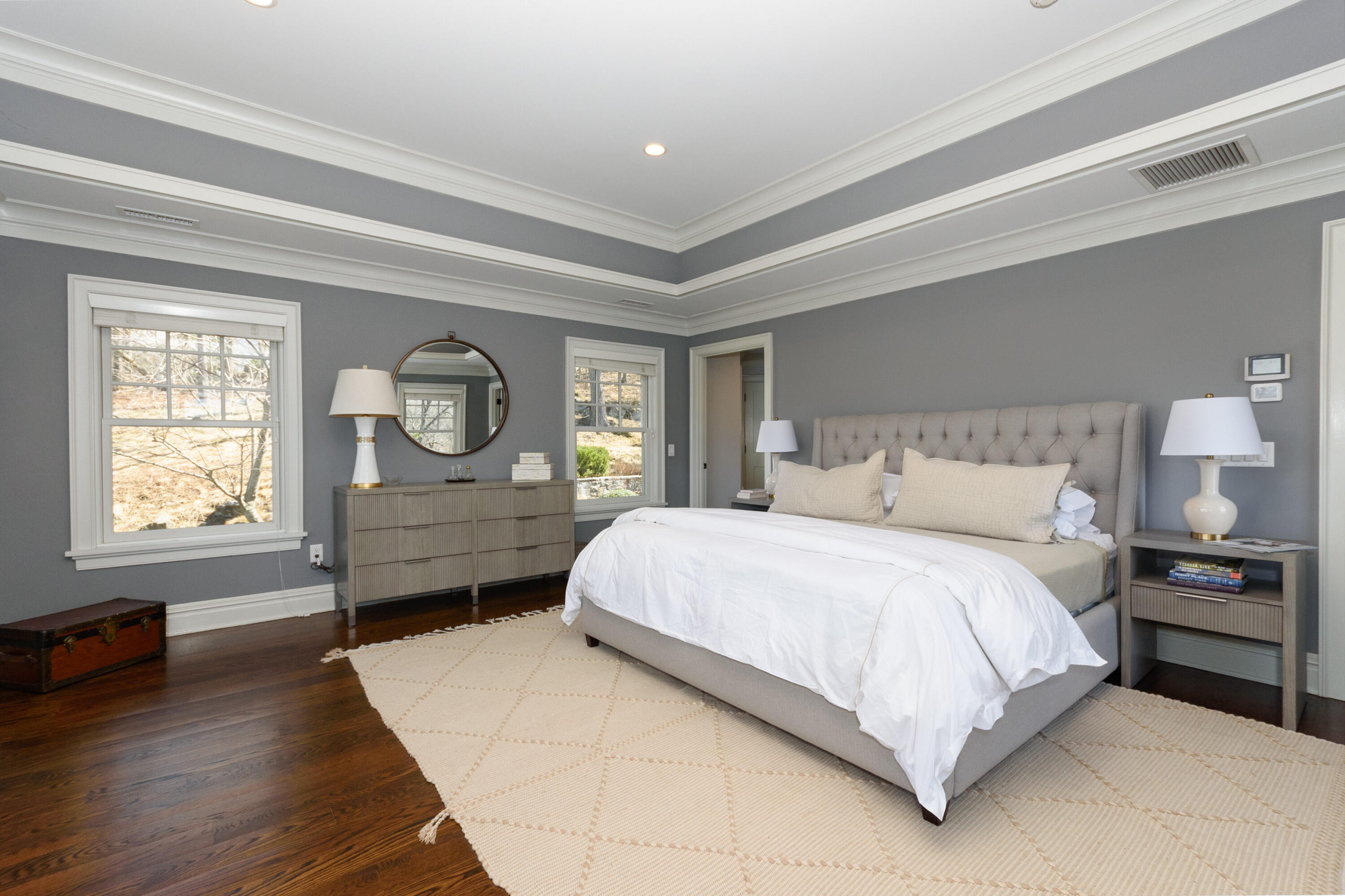 80 Goodwives River Road Darien, CT 06820 - Photo 26 of 57 a bedroom with a bed a mirror on dresser and a wooden floor