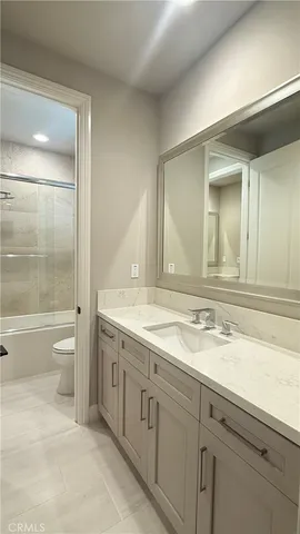 a bathroom with a granite countertop sink a toilet and a bathtub