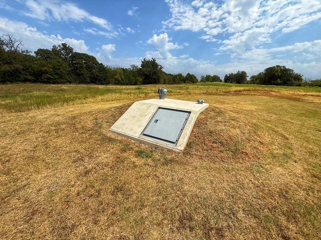 36469 1330th Road Wewoka, OK 74884 - Photo 18 of 39 Concrete structure with a metal door, integrated into a grassy mound