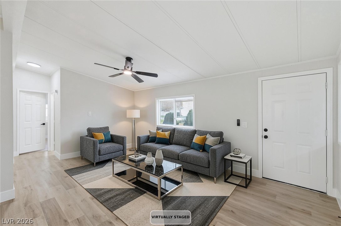 3940 Point Drive Pahrump, NV 89060 - Photo 7 of 35 A comfortable gathering space features light hardwood flooring and a functional ceiling fan.