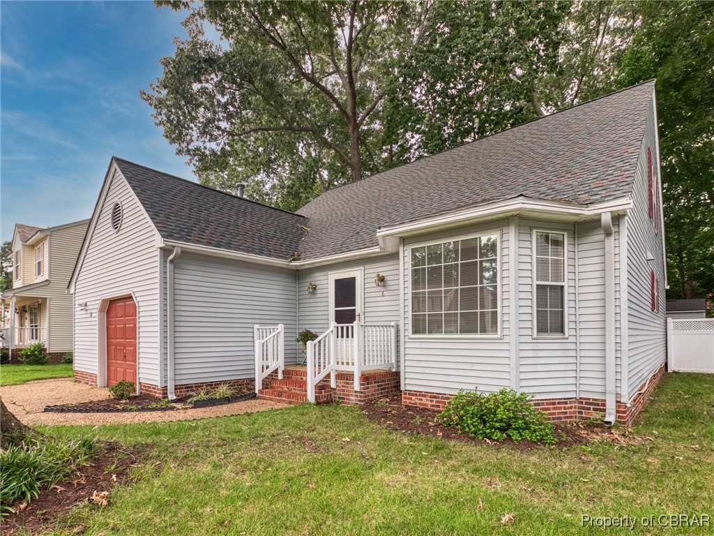 View of front of house featuring a front lawn and a garage