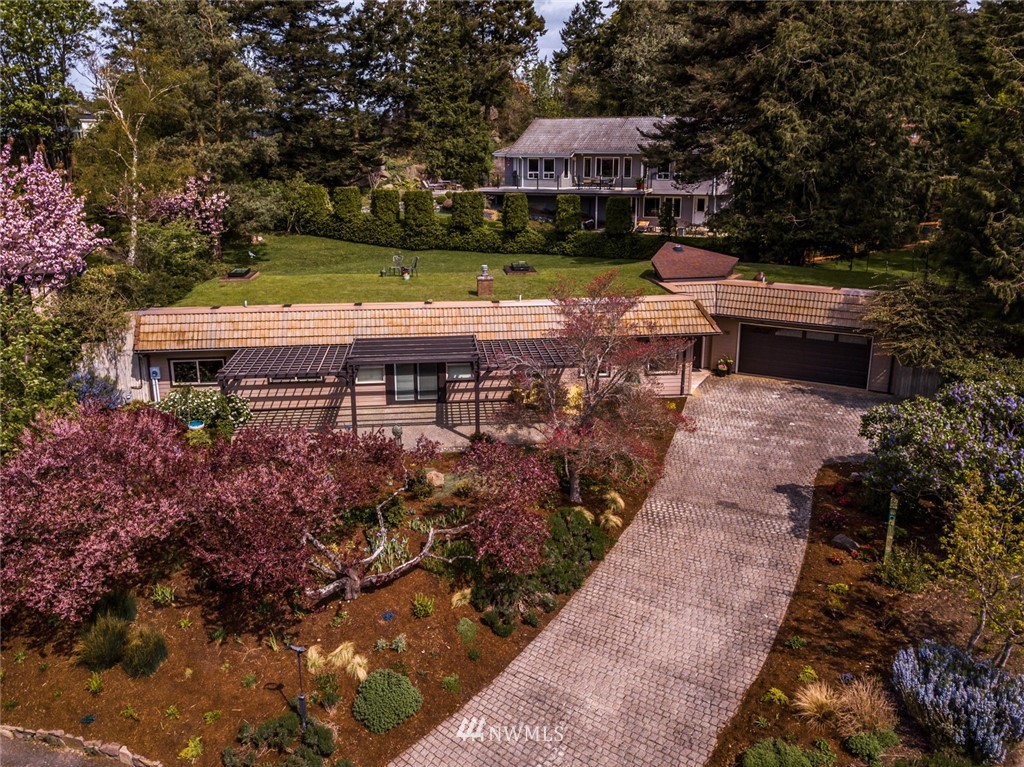 710 Fieldston Road Bellingham, WA 98225 - Photo 2 of 27 a view of a patio with table and chairs under an umbrella with large trees