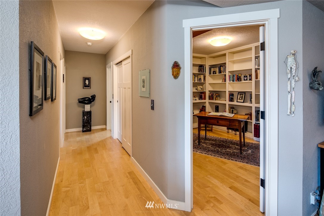 710 Fieldston Road Bellingham, WA 98225 - Photo 12 of 27 a view of a hallway with wooden floor and a bathroom