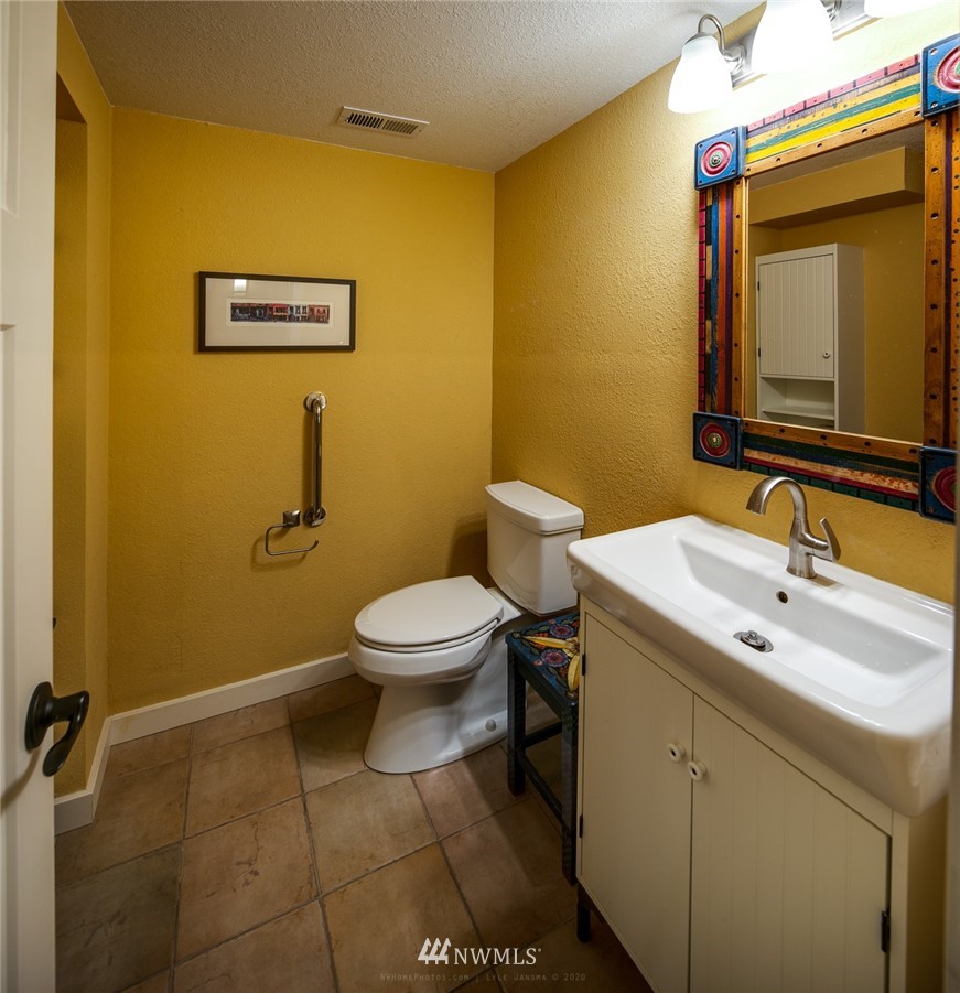 710 Fieldston Road Bellingham, WA 98225 - Photo 25 of 27 a bathroom with a toilet sink vanity and mirror