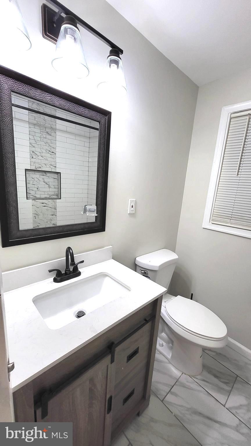 3339 Acton Road Parkville, MD 21234 - Photo 15 of 37 a bathroom with a toilet a sink and mirror