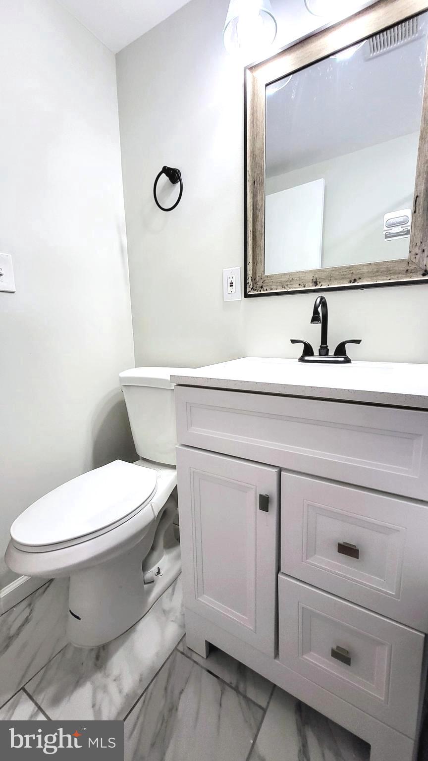 3339 Acton Road Parkville, MD 21234 - Photo 21 of 37 a bathroom with a toilet sink and mirror