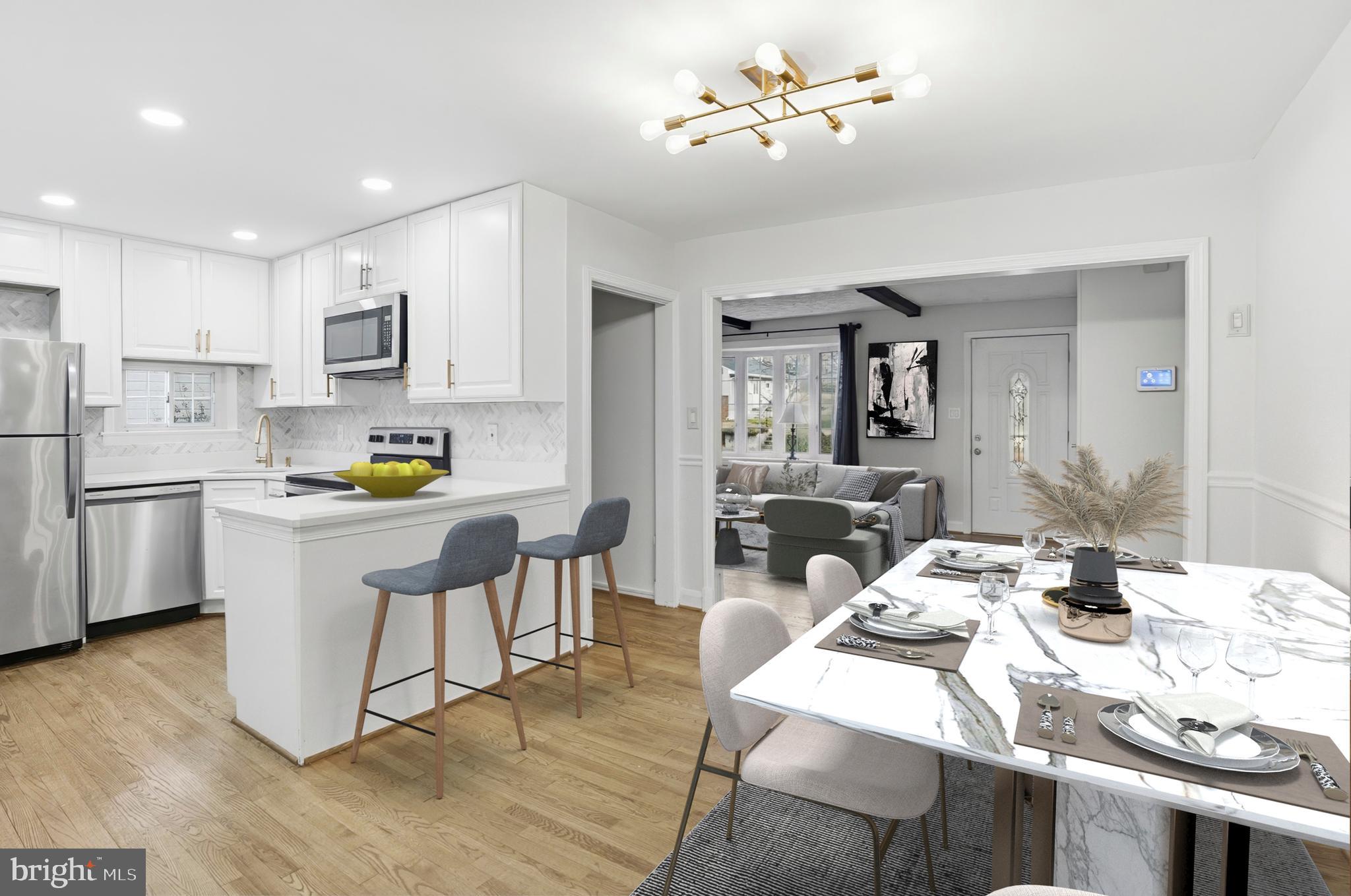 3339 Acton Road Parkville, MD 21234 - Photo 8 of 37 a kitchen with stainless steel appliances kitchen island granite countertop a sink dishwasher a stove a refrigerator a dining table and chairs with wooden floor