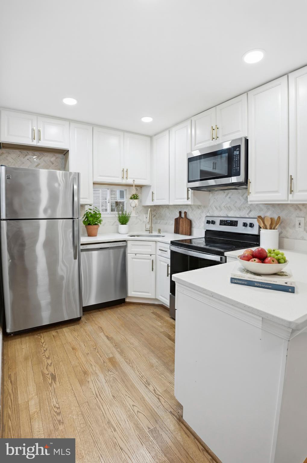 3339 Acton Road Parkville, MD 21234 - Photo 9 of 37 a kitchen with stainless steel appliances a refrigerator sink and white cabinets